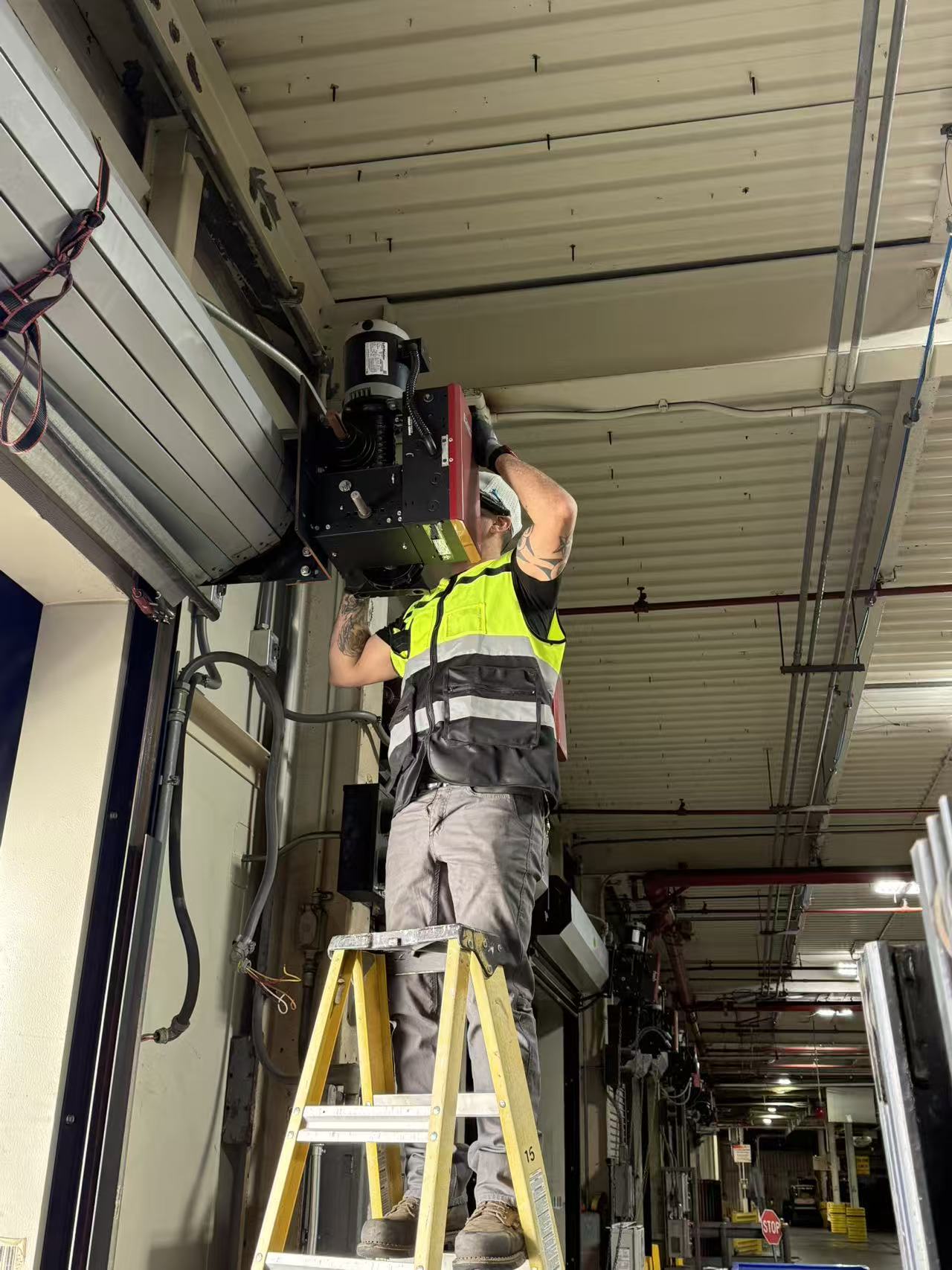 InSev Tech technician servicing a commercial door operator at an active warehouse dock
